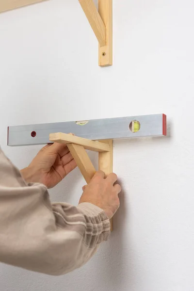 Man Hangs Shelf Apartment White Wall Worker Checks Evenness Shelf — Stock Photo, Image