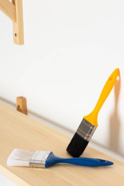 Boya fırçaları ahşap bir raftadır. Rafları cilalama ya da boyama işlemidir.