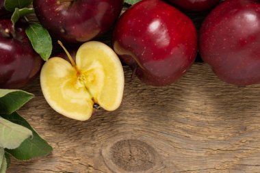 Yeşil yapraklı kırmızı elmalar ahşap arka planda, sonbahar kırsal arka planda