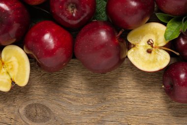 Yeşil yapraklı kırmızı elmalar ahşap arka planda, sonbahar kırsal arka planda