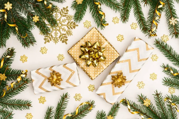 Altın madalyalı şenlikli arka plan, yeşil ladin dalları ve parlak altın yılan konfetisi, yaylı altın hediye kutuları, parlak kar taneleri, düz yataklar, üst manzara