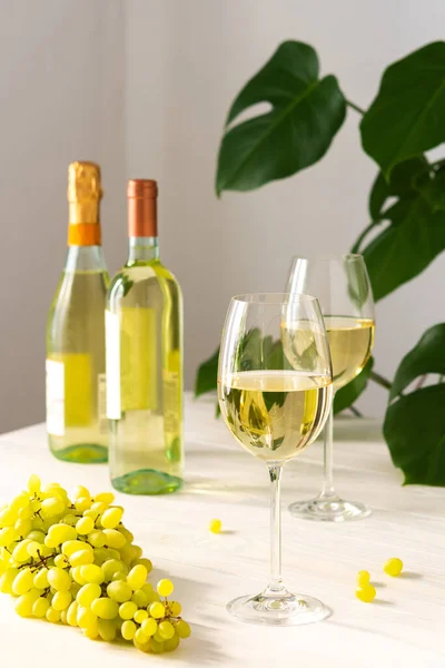 Due Bicchieri Con Vino Bianco Bottiglie Sfondo Bianco Legno Fiore — Foto Stock
