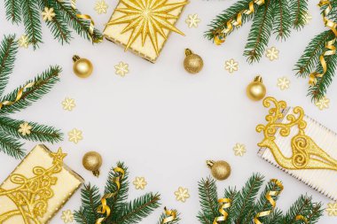 Altın madalyalı şenlikli arka plan, yeşil ladin dalları ve parlak altın yılan konfetisi, altın geyik ve hediye kutuları, pırıl pırıl kar taneleri, düz yatış, üst manzara, kopyalama alanı
