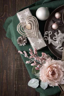 Yelkenli şampanyadaki Noel kompozisyonu, yeşil ve gri gözlükler, noel baloları ve mum, kurabiye kesiciler ve yeşil masa örtüsü üzerindeki dekoratif çiçek, üst manzara, kopyalama alanı