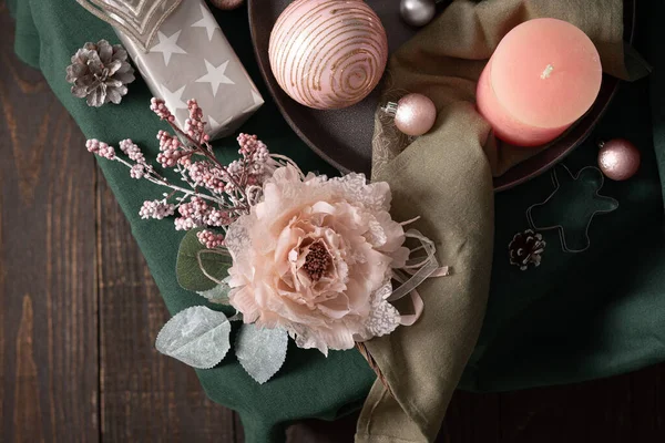 Christmas composition in sail champagne ,green and gray shades, christmas balls and candle, cookie cutters and decorative flower on a green tablecloth, top view, copy space