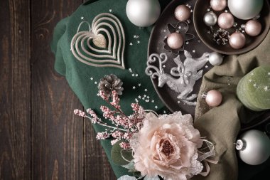 Yelkenli şampanyadaki Noel kompozisyonu, yeşil ve gri gözlükler, noel baloları ve mum, kurabiye kesiciler ve yeşil masa örtüsü üzerindeki dekoratif çiçek, üst manzara, kopyalama alanı