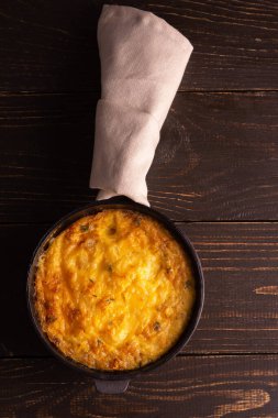 Peynirli frittata, mozzarella ve ahşap arka planda dökme demir bir tavada haşlanmış balkabağı.