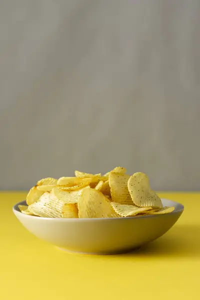 Knusprige Chips Auf Einem Grauen Teller Auf Einem Gelben Tisch — Stockfoto