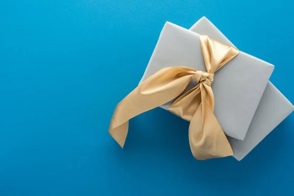 Mavi Arka Planda Altın Fiyonklu Gri Hediye Kutuları Doğum Günü — Stok fotoğraf