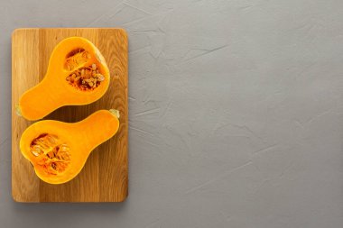 Çiğ organik tereyağlı balkabağı ya da ninem tahta tahtaya yakın plan gri beton arka plan, üst görüş, kopyalama bölmesi