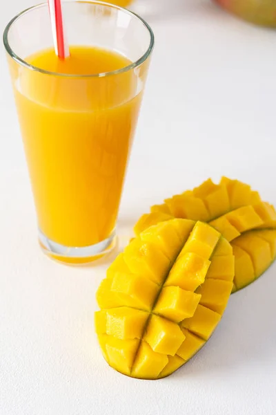 Mango juice in a glass with a straw