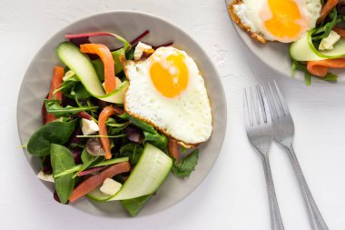 Taze organik mesclun salatası, salatalık, mozzarella ve somon, çırpılmış yumurta, lezzetli ve doyurucu bir kahvaltı.