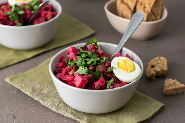 Kaynamış yumurta ve siyah ekmek ile Rus salata sirkesi, haşlanmış patates ve havuç salatası, pancar ve turşu, salatalık ve lahana ve konserve yeşil bezelye.