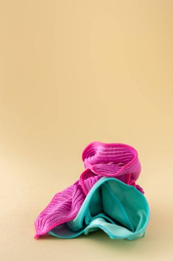 Tarafsız bir bej arka planda yıkanmak için çok renkli mikrofiber kumaşlar, temizlik konsepti.
