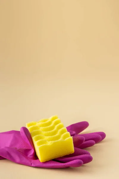 中性米色背景的黄色洗碗海绵和粉色橡胶手套 清洗概念 — 图库照片