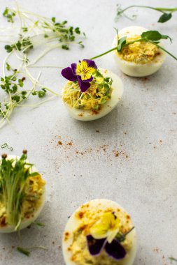 Kızarmış soğan ve mikroyeşillikle doldurulmuş yumurtalar.