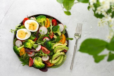 Lezzetli hafif kahvaltı, domatesli salata ve turp, avokado ve haşlanmış yumurta, üst manzara.