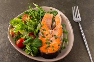 Lezzetli bir öğle yemeği, kızarmış alabalık bifteği ve değişik türde sebze salatası, sağlıklı kırmızı balıklarla akşam yemeği.