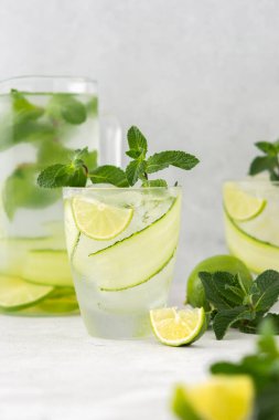 Limonlu ve salatalıklı soğuk, ferahlatıcı içecekler, yaz buzlu içecekler ve taze yeşil nane, limon suyla kaplanmış bardak.