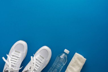 Su şişesi ve havlusu olan spor ayakkabıları.