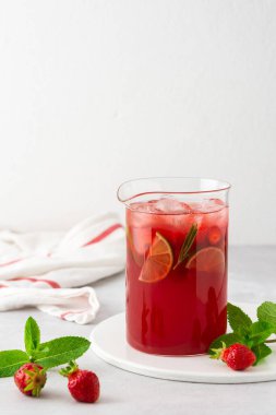 Buzlu ve biberiyeli taze çilek ve limon içeceği. Bir sürahi yakın plan, yaz ferahlatıcı limonata.