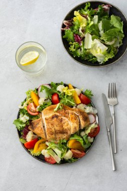 Lezzetli bir öğle yemeği, baharatlı tavuk göğsü ve domatesli salata, turp ve karnabahar karışımı.