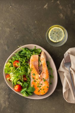 Lezzetli bir öğle yemeği, kızarmış alabalık bifteği ve değişik türde sebze salatası, sağlıklı kırmızı balıklarla akşam yemeği.