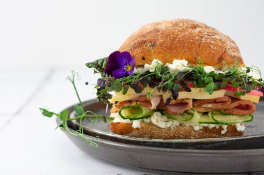 Sosisli, peynirli, salatalıklı, mikroçerezli, mozzarellalı ve turplu çörek. Evde pişirilmiş lezzetli bir tabakta yakın plan burger.