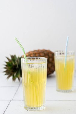 Lezzetli tatlı taze ananas suyu bardakta buzla birlikte pipetle