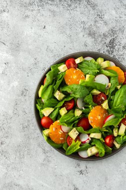 Ispanak yaprakları, mandalina ve avokado dilimleri, çekirdekli domates ve turp, yakın plan salata, üst görünüm, kopyalama alanı