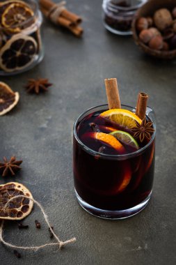 Limonlu ve portakal dilimli sıcak şarap, tarçın ve karanfil, cam bardakta sıcak kış içeceği.