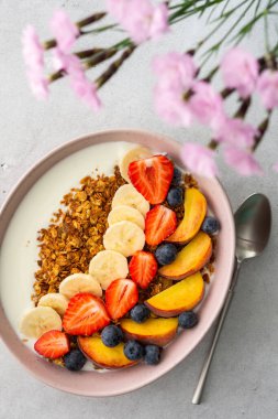 Lezzetli sağlıklı kahvaltı, yoğurtlu granola ve tatlı meyve, muz ve çilek, yabanmersini ve şeftali