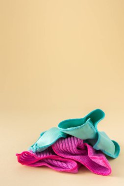 Tarafsız bir bej arka planda yıkanmak için çok renkli mikrofiber kumaşlar, temizlik konsepti.