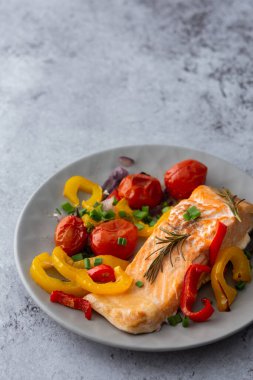 Pişmiş kırmızı balık fileto, sebzeli bir tabakta. Yakından, sağlıklı lezzetli bir akşam yemeği.