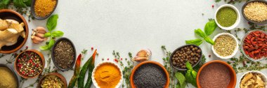 Renkli, taze otlar ve baharatlar gri bir arkaplanı çerçeveliyor. Mutfak yaratıcılığına, üst manzaraya, kopyalama alanına, afişe dikkat çekmek için mükemmel bir doğal sınır.