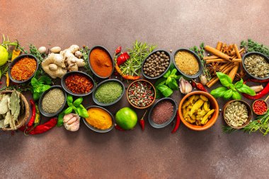 Taze baharat ve otlardan oluşan nefes kesici bir serpinti, titizlikle kahverengi bir zemin üzerine yerleştirilmiş, canlı renklerini ve aromalarını yakalıyor.