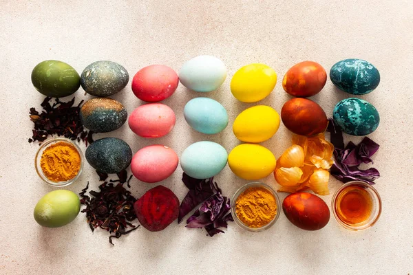 Parlak renkli Paskalya yumurtaları, pancar, zerdeçal ve amber, kırmızı lahana ve soğan kabuğu, sirke, sirke gibi bitkilerden yapılan doğal boyalarla çevrelenmiş yaratıcı bir düzende sıralanmıştır.