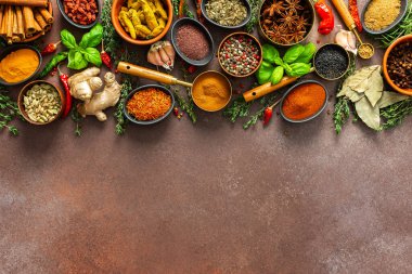 Canlı, taze kokulu baharat ve bitkilerden oluşan bir koleksiyon. Kahverengi bir arka planda renkli bir şekilde sergileniyor. Doğal ve aromatik güzelliklerini sergiliyorlar.