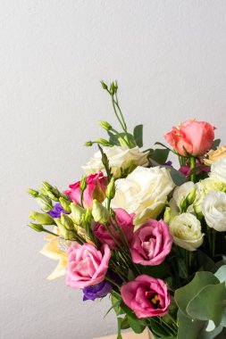 Güzel bir buket canlı gül, okaliptüs, ve beyaz, pembe ve mor renkte narin bir östoma, yıldönümü veya doğum günü kutlaması için mükemmel.