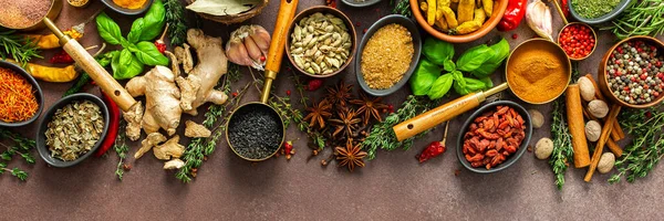 Kahverengi bir yüzeye karşı dizilmiş baharat ve otların zarif bir düzeni, aromatik zenginliklerini, görsel çeşitliliklerini, afişlerini vurguluyor.