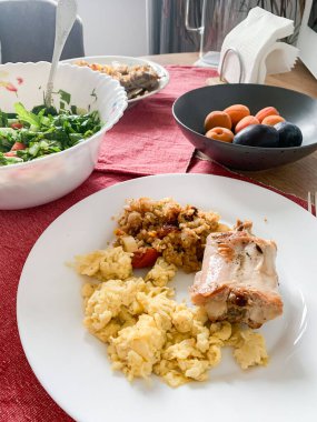 Kahvaltıda bir tabak omlet, kinoa ve taze salata ile birlikte tavşan eti servis edilir. Kayısı ve erik yanında tatlı olarak..