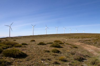 Temiz elektrik, rüzgarlı bir dağ sırtında rüzgar türbinleri üretiyor.