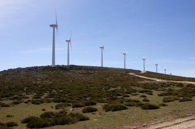 Temiz elektrik, rüzgarlı bir dağ sırtında rüzgar türbinleri üretiyor.