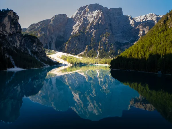 Bereketli, canlı ormanlarla çevrili sakin bir göle yansıyan görkemli dağların nefes kesici manzarası.