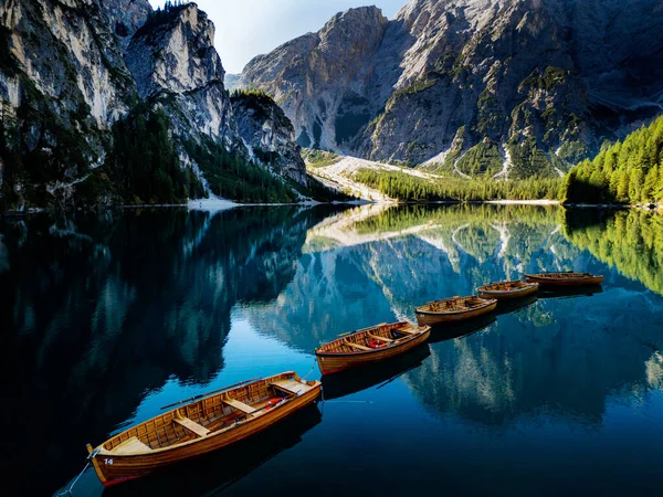 Sakin ve sakin bir göl, yukarıdaki açık mavi gökyüzünün altında görkemli dağlarla güzel bir şekilde çevrilidir.