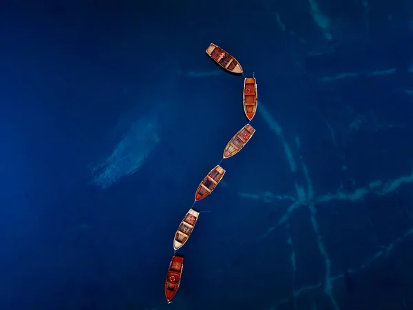 Çarpıcı ve güzel bir ahşap tekne dizilimi sakin, derin mavi sularda huzur içinde yatıyor.