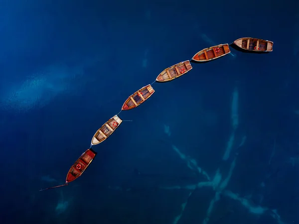 Nefes kesici bir hava manzarası, aşağıda sakin ve sakin mavi sularda güzel hizalanmış kayıklar yakalıyor.