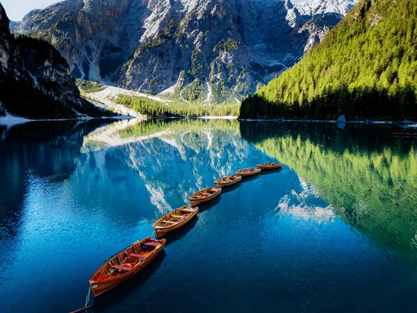 Etrafındaki tepeleri yansıtan sakin bir dağ gölü ve sudaki kayıklarla dolu bereketli ormanlar..