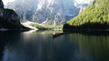 Tahta kayıklı Alp Gölü, ayna benzeri dağ yansımaları ve her zaman yeşil olan ormanlar - sakin yaz manzarası