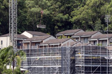 Kule vincinin yeni inşaat alanına çalı zeminli malzeme getirmesi ile ilgili inşaat devam ediyor. 56-58 Beane St. Gosford 'da yeni sosyal konut geliştirme birimi. 3 Mart 2021. Avusturalya.